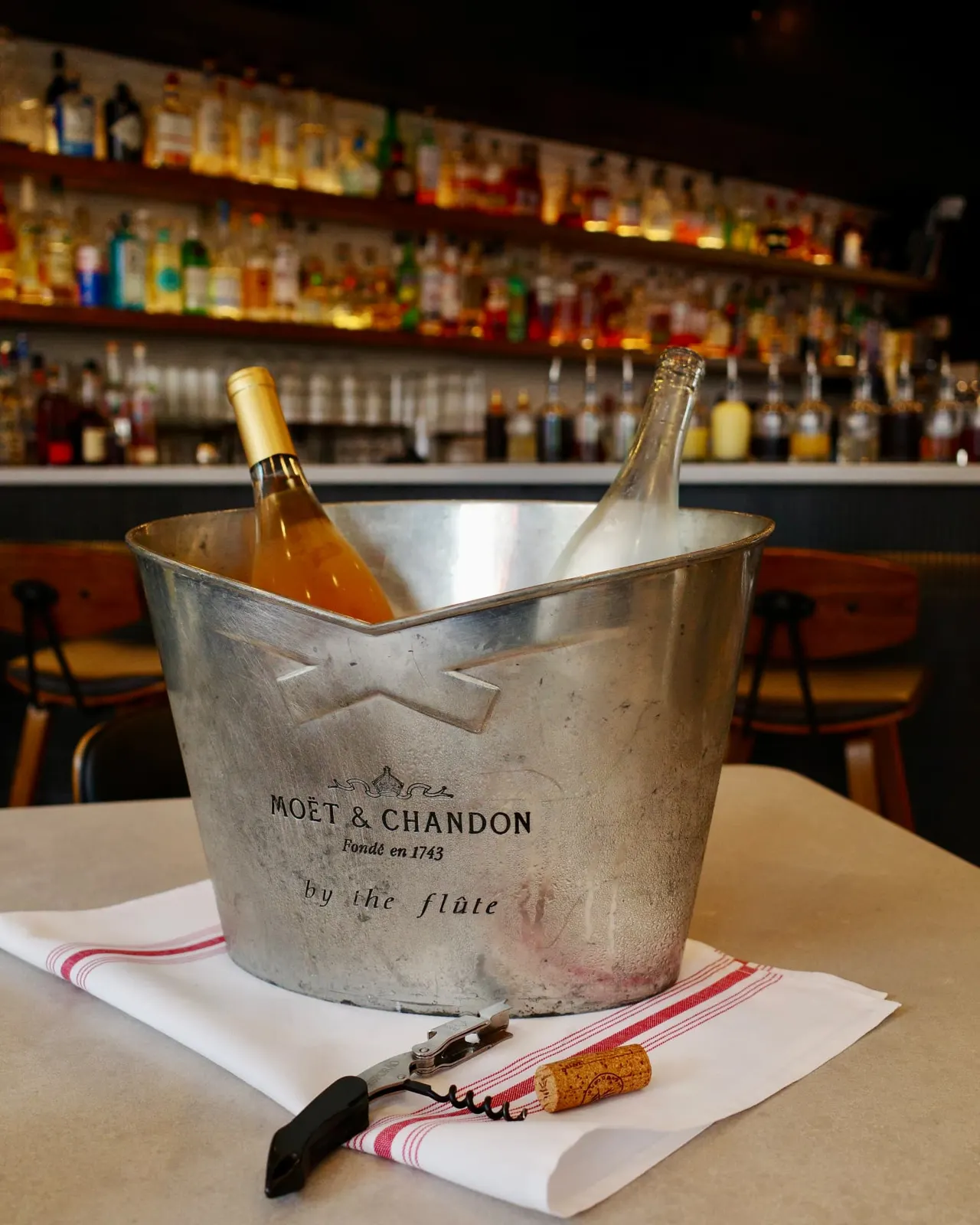 A chilled bottle of wine in an ice bucket on a table at Five Corners Ristorante